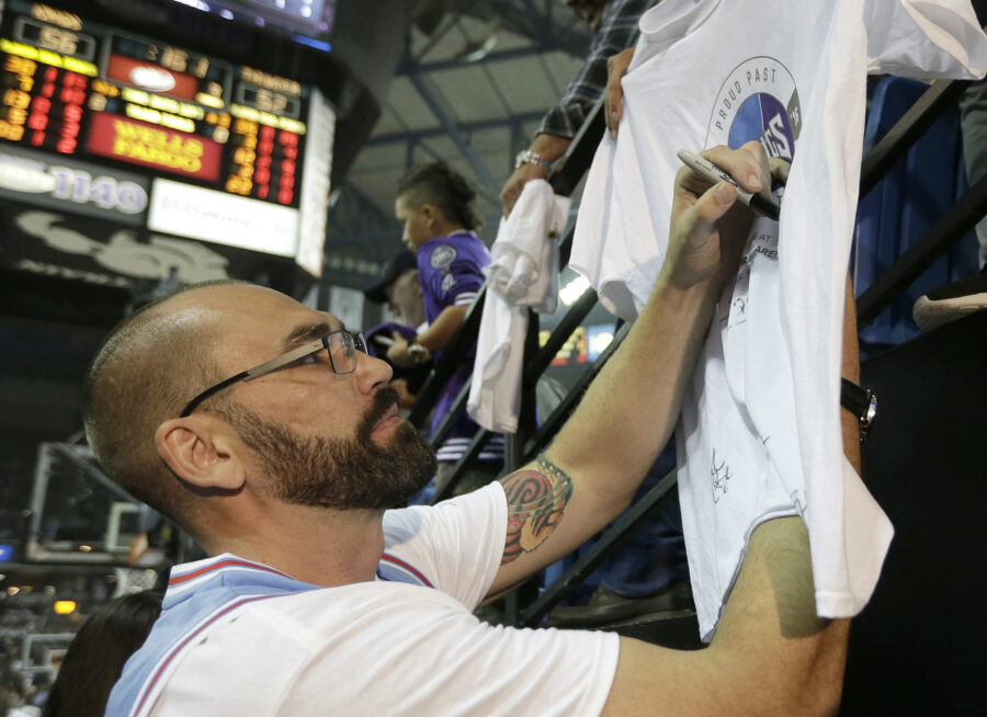 FILE - Former Sacramento Kings player Scot Pollard signs an autograph during the half time of the K...
