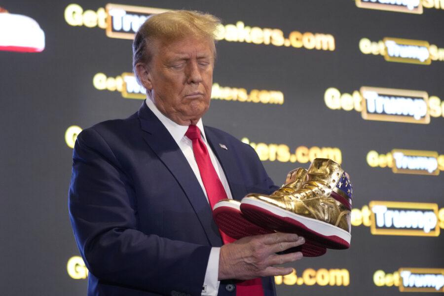 Republican presidential candidate former President Donald Trump holds gold Trump sneakers at Sneake...