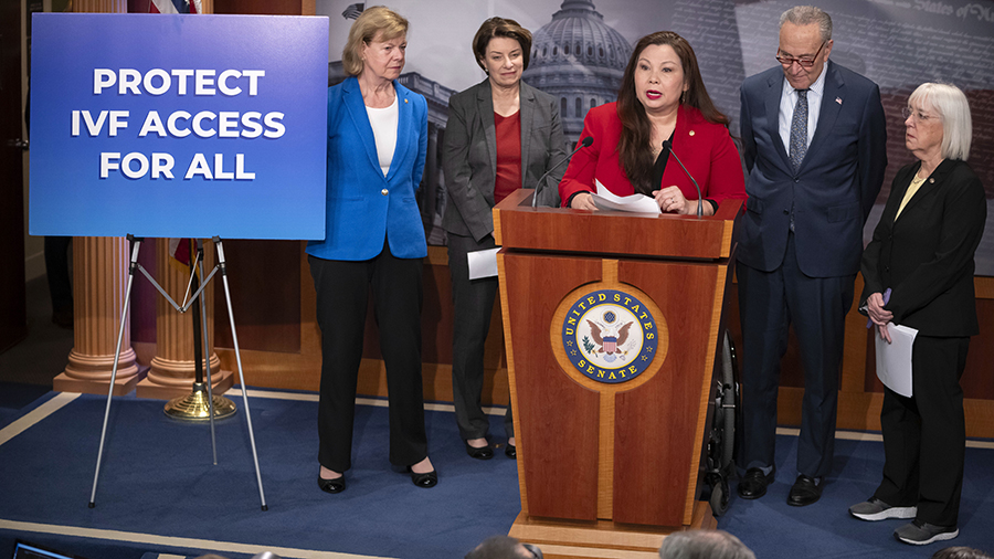 Sen. Tammy Duckworth, D-Ill., center, speaks about a bill to establish federal protections for IVF ...