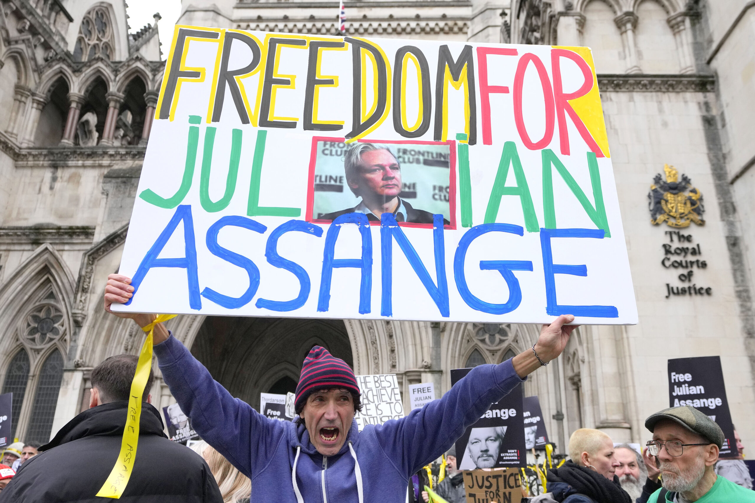 Demonstrators hold banners outside the Royal Courts of Justice in London, Tuesday, Feb. 20, 2024. W...