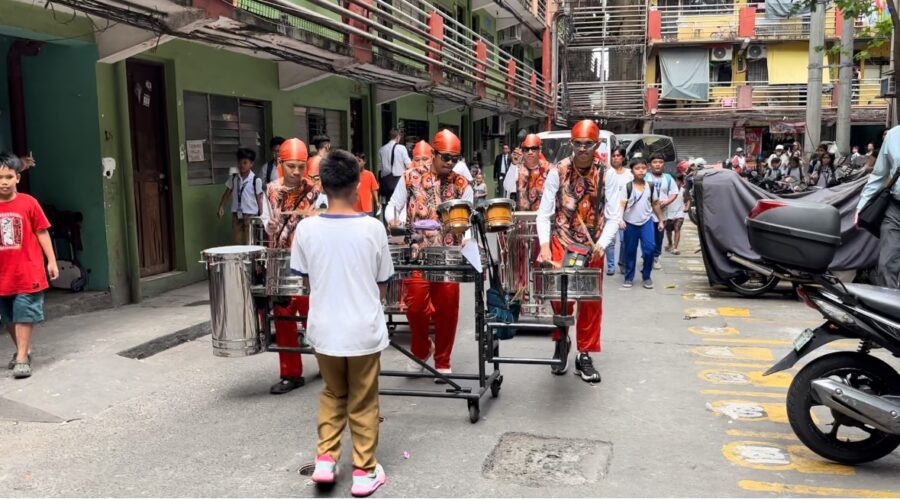 A boy leads a band through a community near Manila, Philippines....
