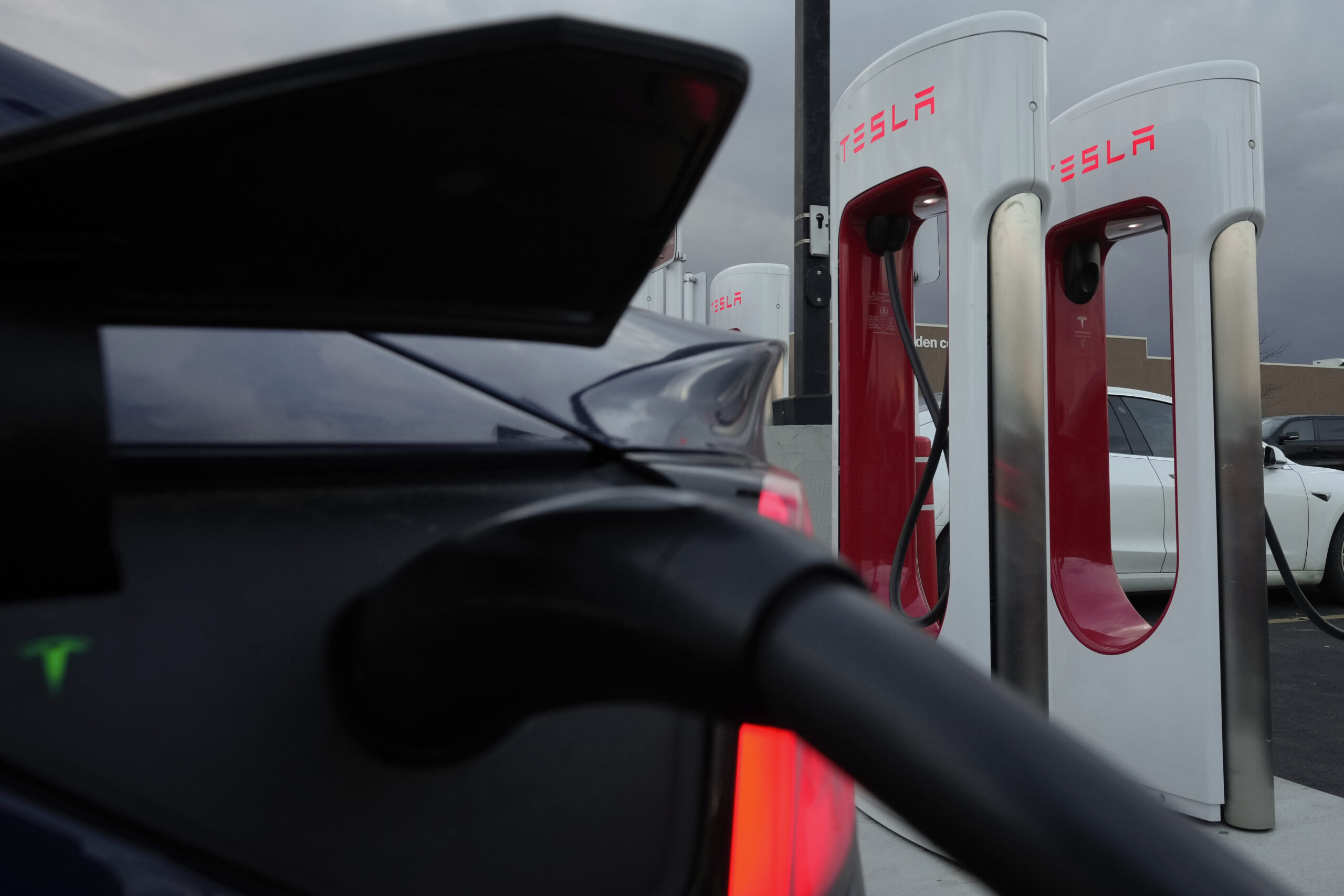 FILE - A vehicle charges at a Tesla Supercharger station in Detroit, Nov. 16, 2022. Owners of Ford ...
