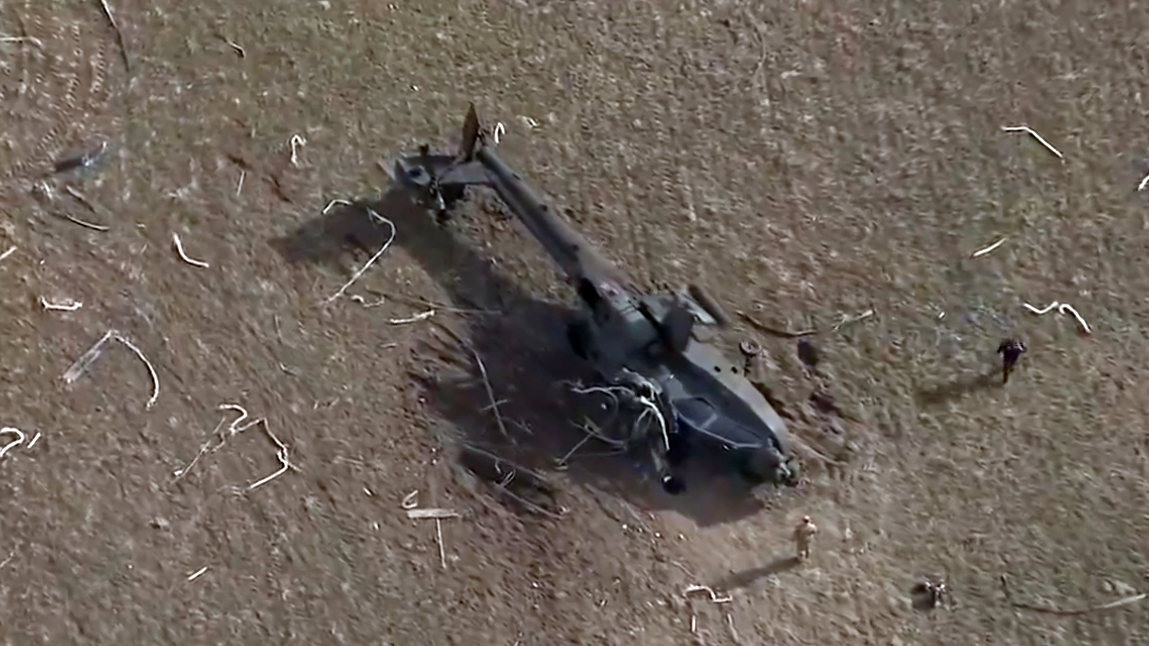 crashed Apache helicopter on a dirt field...
