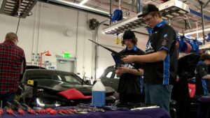 Student gearheads working on a car. 
