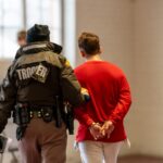 A Utah Highway Patrol trooper escorts a person under arrest into the law enforcement processing center. (Salt Lake City Police Department)