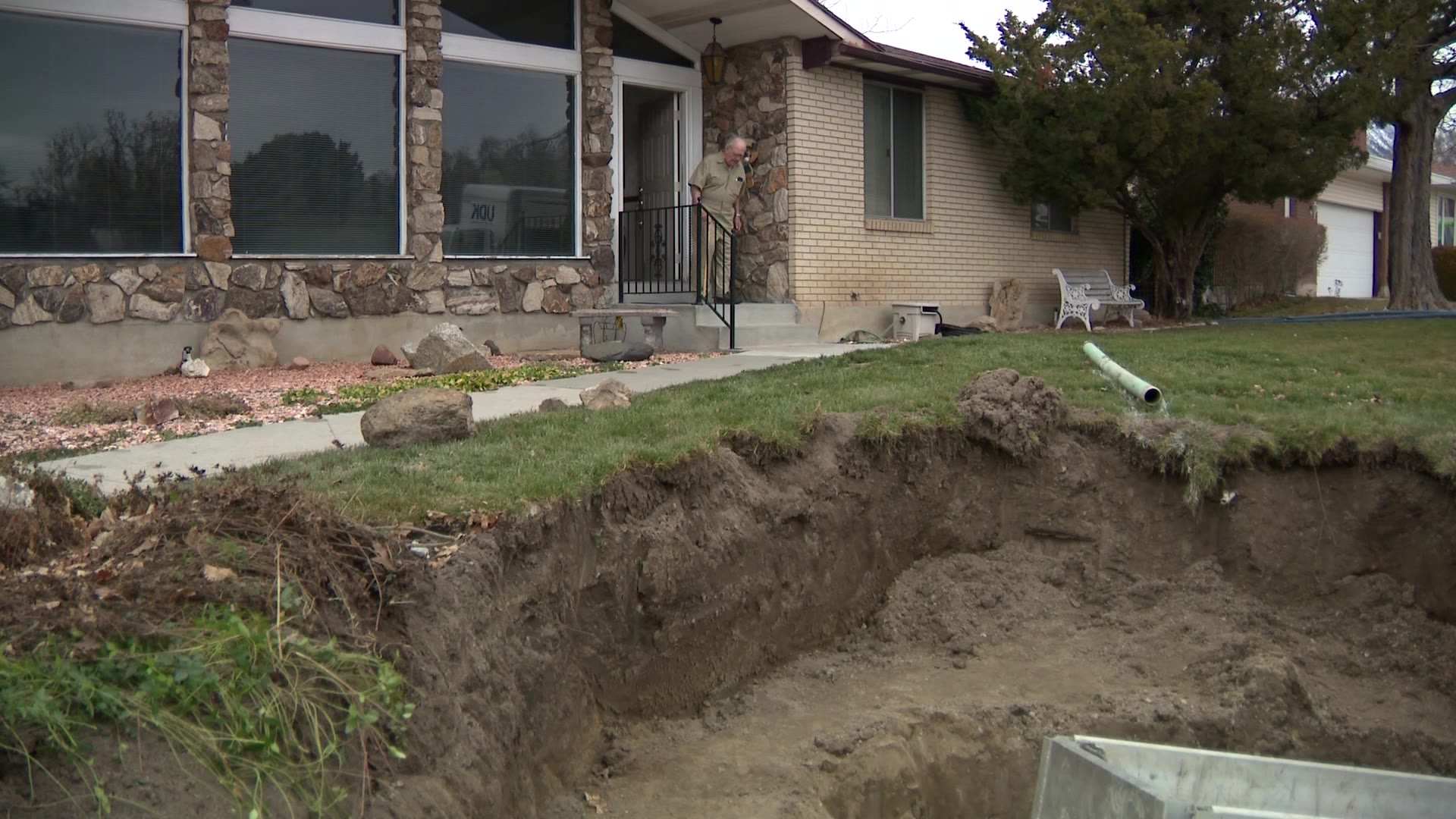 man looks from his porch into a massive hole in his yard...