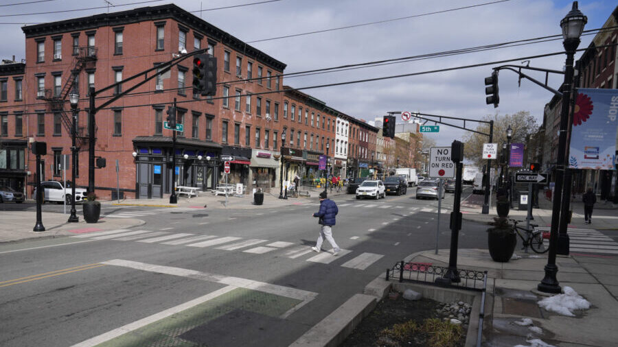 Pedestrians cross the street at the intersection of Washington and 5th in Hoboken, N.J., Thursday, ...