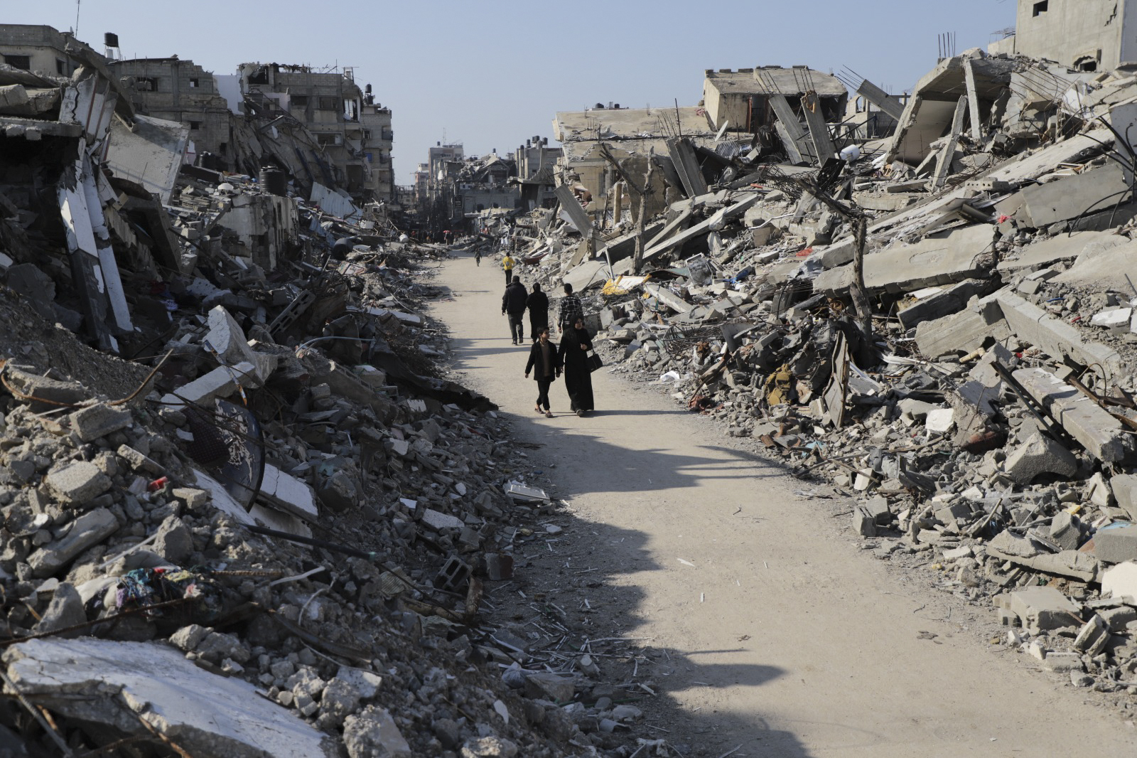 Palestinians walk through the destruction from the Israeli offensive in Jabaliya refugee camp in th...
