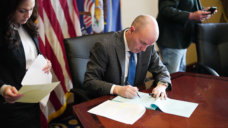 Utah Gov. Spencer Cox signing bills and vetoing seven while in his office....