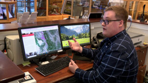 man sits at a computer with a map of Davis County
