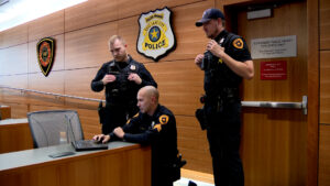 The three officers watching the replay of the video. 