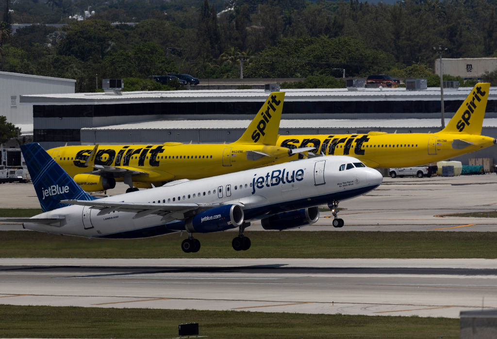 FILE: A JetBlue Airlines plane takes off near Spirit Airlines planes at the Fort Lauderdale-Hollywo...