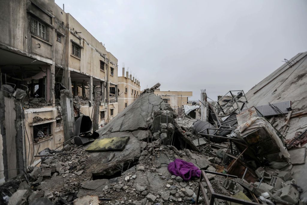 People inspect damage and recover items from their homes following Israeli air strikes on February ...
