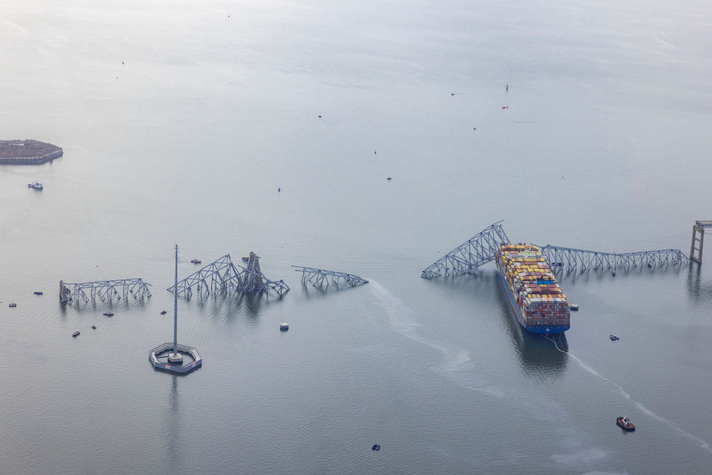 In an aerial view, the cargo ship Dali sits in the water after running into and collapsing the Fran...