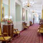 A hallway featuring architectural details of red and gold carpet as well as the wood chairs with gold accents inside the Manti Utah Temple of The Church of Jesus Christ of Latter-day Saints. (Courtesy Intellectual Reserve, Inc.)