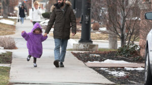 Navied Mahdavian walking down a Salt Lake City street with his daughter.