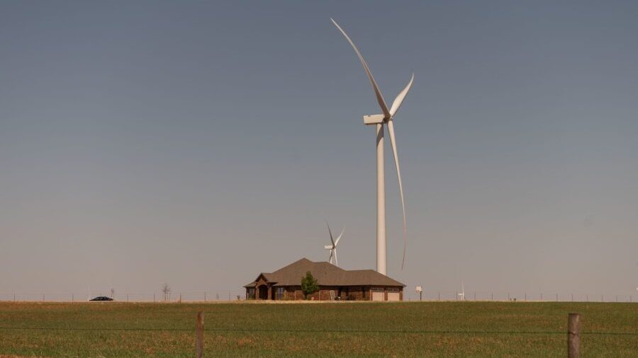 Wind turbines tower above a home in Weatherford, Oklahoma, in April 2022. As wind energy expands in...