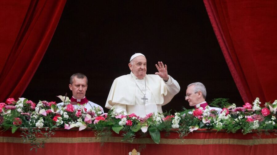 Pope Francis waves from a balcony on Easter Sunday. Francis called for an "immediate ceasefire" dur...