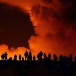 Spectators watch plumes of smoke from volcanic activity between Hagafell and Stóra-Skógfell in Iceland on March 16. (Marco di Marco, Associated Press)