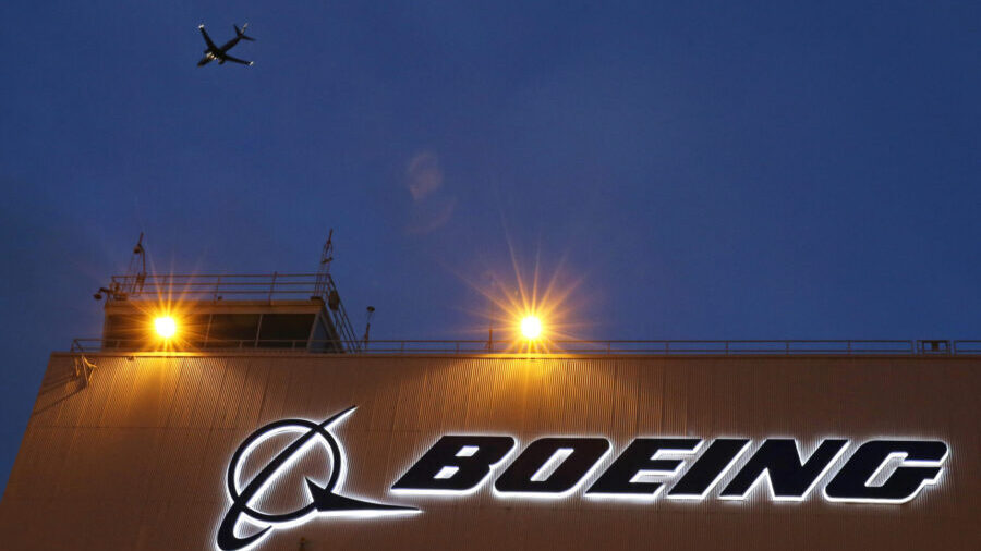 FILE - An airplane flies over a sign on Boeing's 737 delivery center, Oct. 19, 2015, at Boeing Fiel...