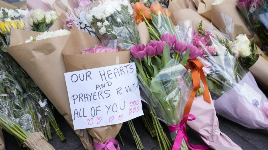 A note is left with flower tributes near a crime scene at Bondi Junction in Sydney, Sunday, April 1...