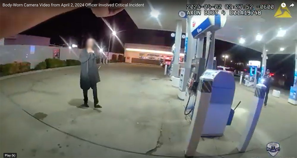 man stands near gas pumps in a parking lot...