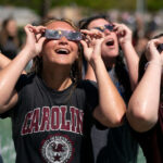 COLUMBIA, SOUTH CAROLINA - APRIL 8: University of South Carolina students look at an eclipse after playing in a fountain following an NCAA Women's Basketball Championship celebration at the Colonial Life Arena on April 8, 2024 in Columbia, South Carolina. University classes that were scheduled during the event were canceled. (Photo by Sean Rayford/Getty Images)