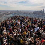 NEW YORK, NEW YORK - APRIL 08: People watch a partial solar eclipse on the observation deck of Edge at Hudson Yards on April 08, 2024 in New York City. While New York City isn't in the path of totality, it will see up to 90% of the sun covered by the moon. Around New York and in the path of totality, millions of residents and tourists are preparing for a total solar eclipse. (Photo by Spencer Platt/Getty Images)