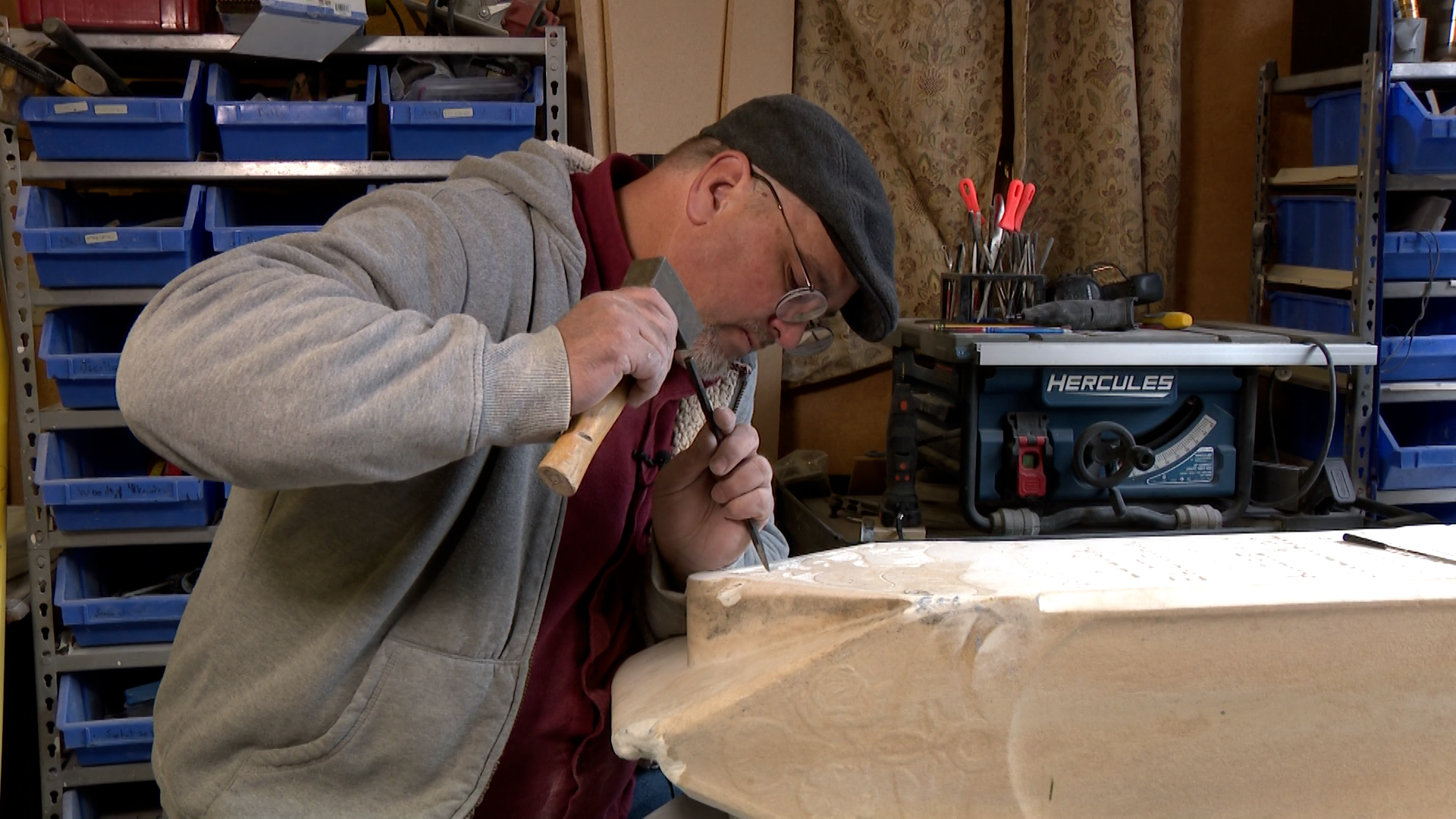 Jason Millward using a hammer and chisel to carve out the stone on the tombstone. (Lauren Steinbrec...