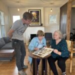 Steven Park, Dorothy Switzer, and Becky McDonald look over photos of the Springville home. (Eliza Pace, KSL TV)