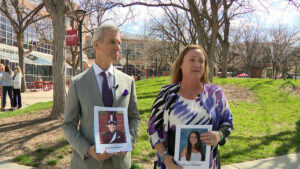 Max Schachter and Lori Alhadeff holding signs of the children they lost in the 2018 Parkland shooting. 