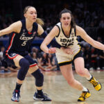 CLEVELAND, OHIO - APRIL 05: Caitlin Clark #22 of the Iowa Hawkeyes dribbles around Paige Bueckers #5 of the UConn Huskies in the second half during the NCAA Women's Basketball Tournament Final Four semifinal game at Rocket Mortgage Fieldhouse on April 05, 2024 in Cleveland, Ohio. (Photo by Steph Chambers/Getty Images)