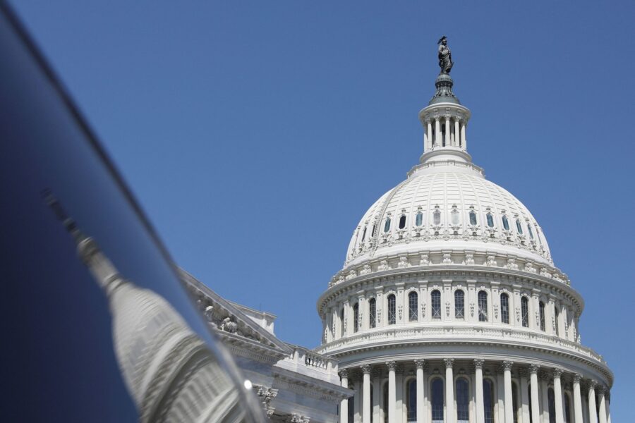 The dome of the U.S. Capitol is reflected in a window on Capitol Hill in Washington, DC, in April 2...