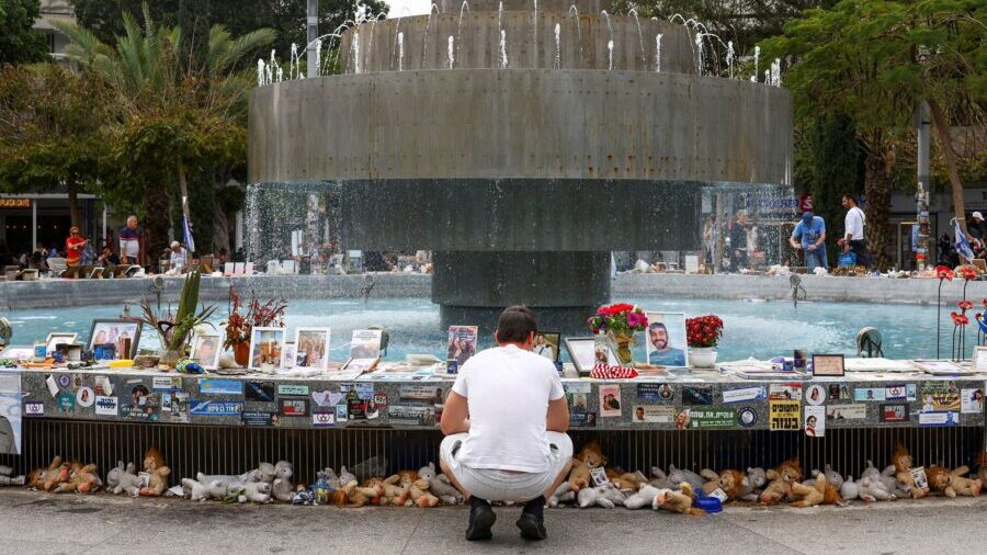 A man looks at memorabilia and pictures of the hostages kidnapped in the October 7 attack, displaye...