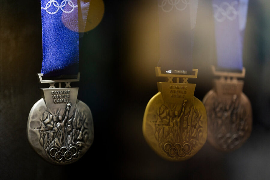 Gold, silver, and bronze Olympic medals hung in a museum display...