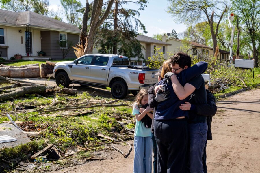 Neighbors embrace Penny Thomsen outside of her home after multiple tornadoes ripped across the stat...