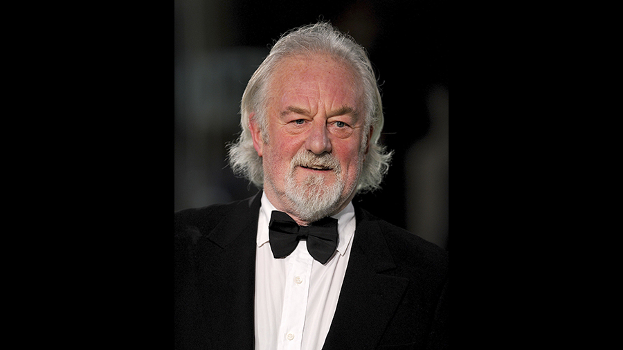 Man in tuxedo with a white beard and hair...