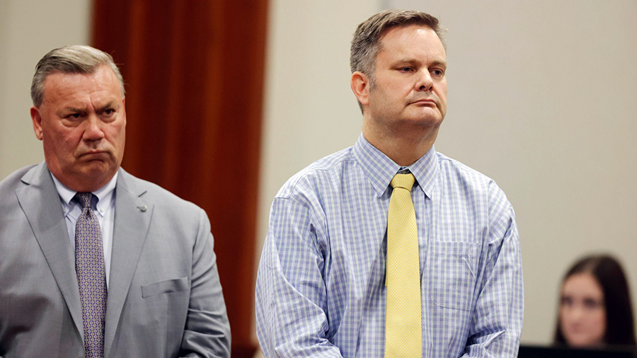 Chad Daybell in a courtroom in a blue checkered shirt and solid yellow tie...