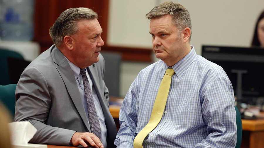 Chad Daybell in a courtroom in a blue checkered shirt and solid yellow tie...