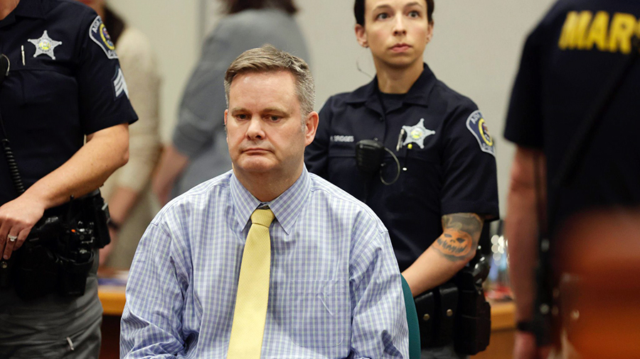 Chad Daybell in a courtroom in a blue checkered shirt and solid yellow tie...