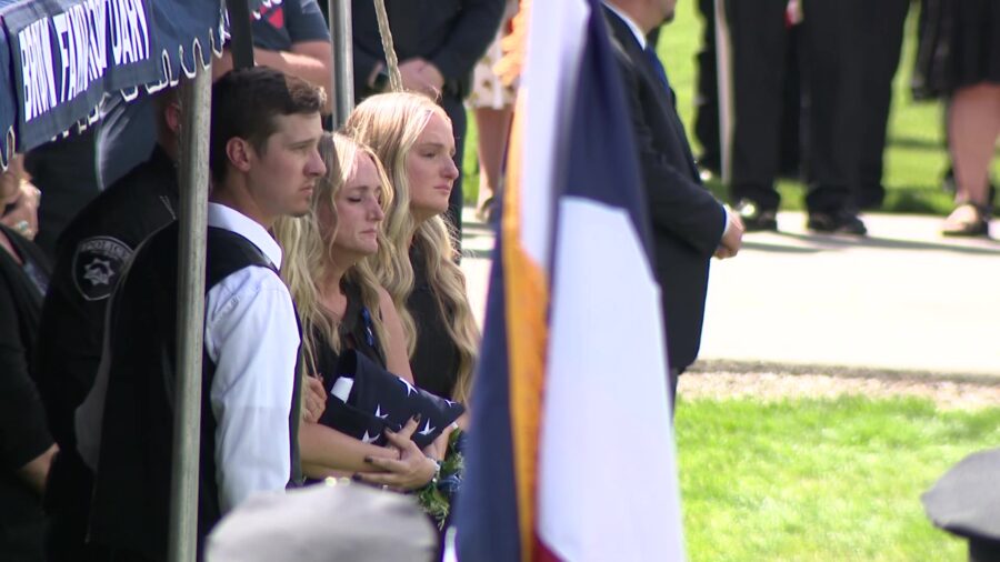 The family of fallen Santaquin Police Sgt. Bill Hooser sit next to 
his casket during a graveside s...