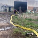 Riverdale firefighters are outside the barn putting out the flames.  (The Riverdale Police Department)