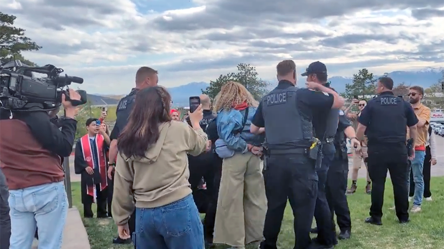 Police surround a cuffed woman...