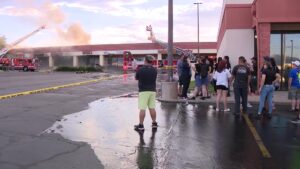 Bystanders watch first responders working on the fire.