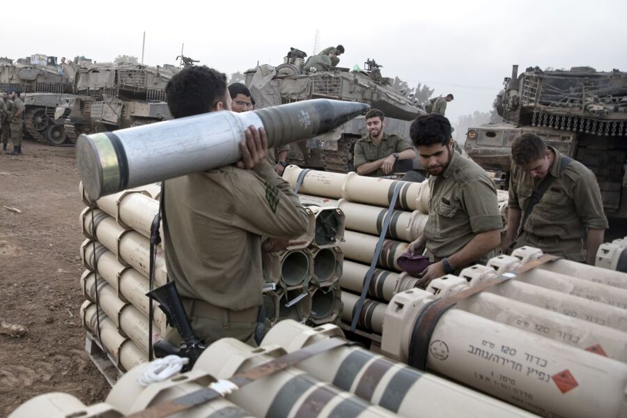 Israeli soldiers organize tank shells after returning from the Gaza Strip at the southern border, I...