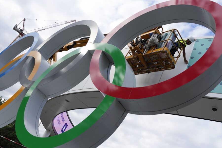 A worker puts on the finishing touches on a sign outside a venue ahead of the 2024 Summer Olympics ...