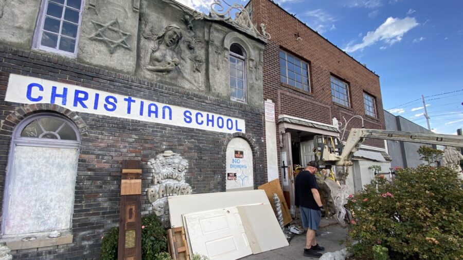 Volunteers are seen carrying artworks out of the Christian School studio and exhibit....